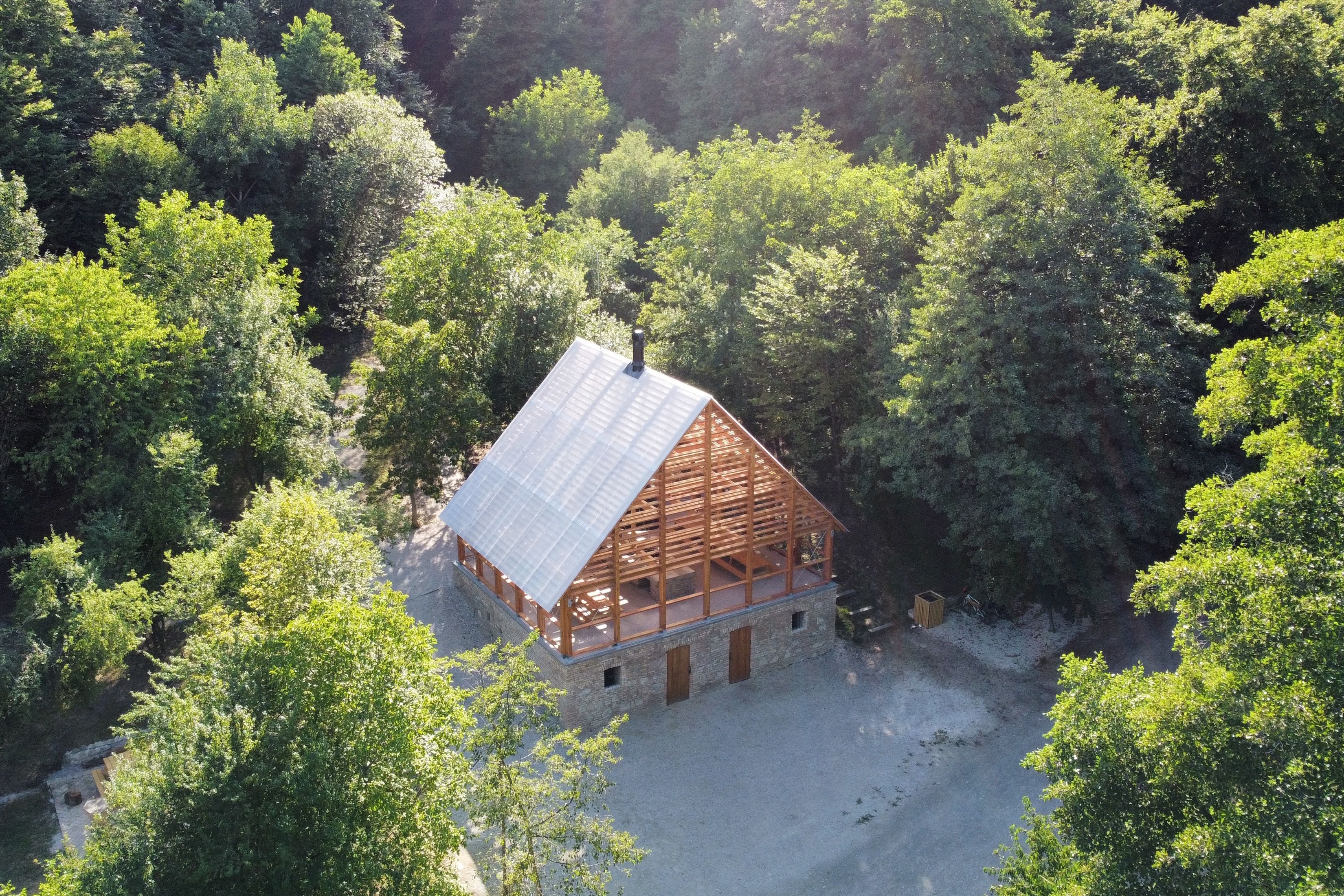 Letecký šikmý pohľad na altánok v zelenej doline pri vodnej ploche